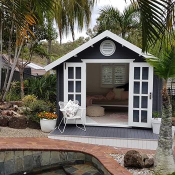 dark grey and white kitset cabin by pool